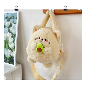 Detail of plush beige cat crossbody bag holding an avocado on a wooden hook