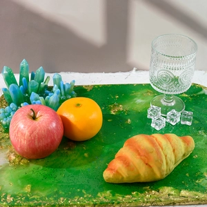 Detalle de bandeja de resina verde con copos dorados y accesorios de comida realistas