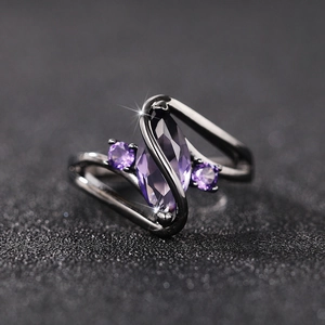 Macro shot of marquise-cut purple zircon stone on a sleek gunmetal black ring band