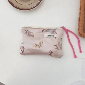 Detail of pink jacquard shoulder bag with colorful butterfly patterns and woven rope