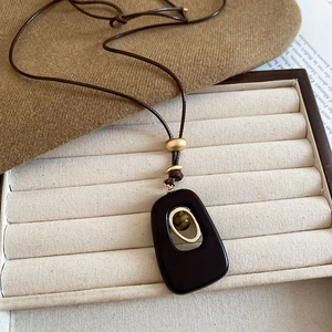 Detailed view of the tiger eye bead inside an oval resin pendant with gold accents
