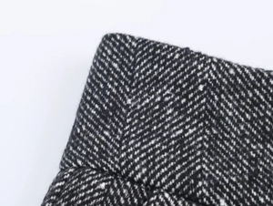 Macro shot of high-quality black and white herringbone wool blend fabric texture for suits