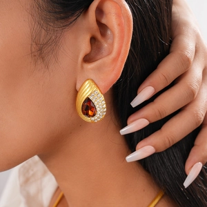 Detailed view of vintage gold snake-shaped drop earring with amber teardrop gemstone