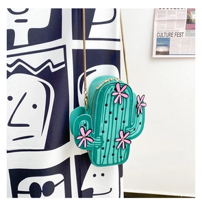 Detail view of a green cactus shoulder bag with pink floral accents and gold chain strap