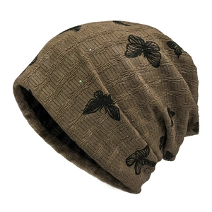 Brown knit beanie with textured square patterns and black butterfly prints and subtle glitter