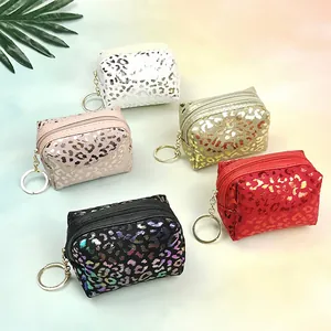 Close-up of five leopard print coin purses with gold zippers and keychain attachments
