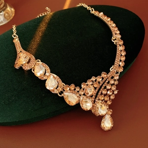 Détail macro du collier vintage doré avec des strass en forme de poire champagne