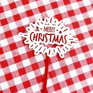 Close-up of red acrylic Merry Christmas cake topper with festive hollow letters