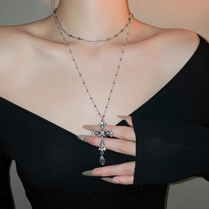 Detail of elegant double-layered silver cross necklace with rhinestones on model