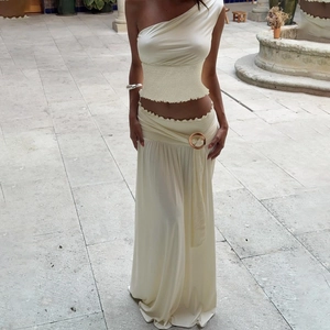 Detail of off-white one-shoulder top and maxi skirt with metal ring accent