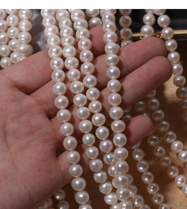 Close-up of 7mm natural freshwater pearls with iridescent luster held in hand