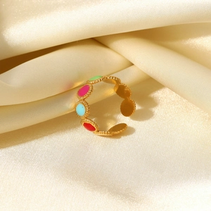 Close-up of 18K gold-plated adjustable ring with colorful enamel oval dots on silk