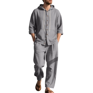 Detail of loose fit dark grey linen hoody and trousers texture on a male model
