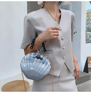 Detail of gray marble texture shell bag with black chunky acrylic chain handle