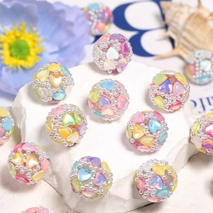 Macro detail of transparent DIY beads with heart sequins and pearls on a stone surface