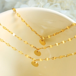 Three-layer gold layered bracelet with minimalist round charms on ceramic bowl edge