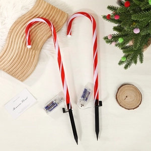 Detail of candy cane lawn lights with red white stripes and clear battery box