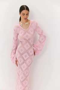 Dettaglio dell'abito lungo in maglia rosa con scollo a V e trama geometrica traforata