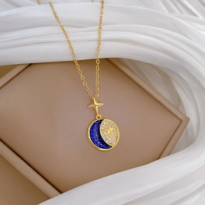 Detailed shot of celestial gold necklace with blue enamel moon and sparkling star charms