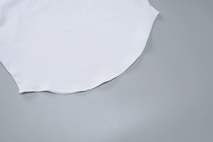 Détail d'un crop top blanc en maille côtelée avec ourlet arrondi et tissu texturé