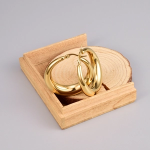 Pendientes de aro de media luna chapados en oro de 18K sobre base de madera minimalista