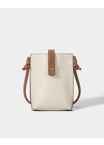 Detailed view of cream-colored pebble leather phone bag with brown crossbody strap