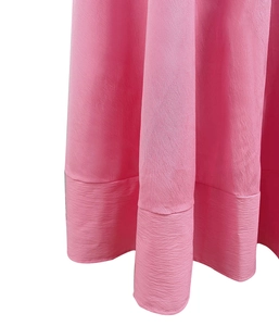 Dettaglio dell'orlo rosa pesca con trama in crepe e cuciture ampie di alta qualità