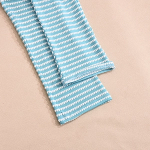 Detail of blue and white striped knit fabric showing ribbed texture and stitching quality