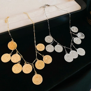 Detail of vintage coin pendants with embossed figures in gold and silver finishes
