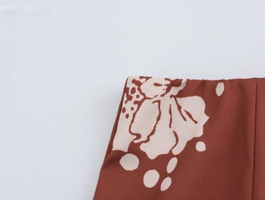 Vue détaillée du tissu brun-rouge avec un motif d'ours beige et une texture tissée