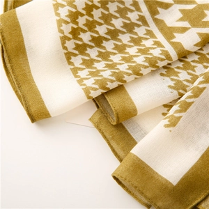 Detailed texture of yellow houndstooth scarf showing soft weave and refined edges
