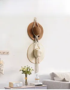 Detail of macrame wall hanging hat organizer with two sections and fringe tassels