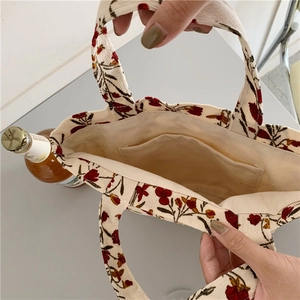 Interior detail of floral corduroy tote bag showing beige cotton lining and inner pocket