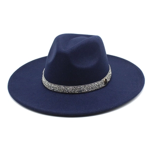 Detail view of navy blue fedora hat with sparkling silver rhinestone band and metal logo