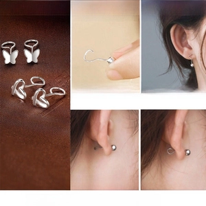 Macro view of S999 silver butterfly earrings showing hook design and wearing process