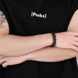 Close-up of men's punk rock matte black braided metal chain bracelet on wrist