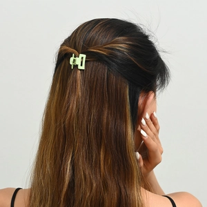 Détail d'une mini pince à cheveux carrée vert clair de 2,5 cm sur une coiffure mi-haute