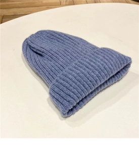 Dettaglio del berretto in maglia a coste grigio-blu con ampio risvolto protettivo