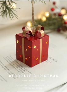 Détail d'un ornement de boîte cadeau rouge de Noël avec étoiles et lumière LED chaude