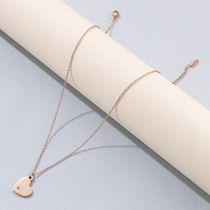Gros plan du pendentif cœur or rose avec cristal et fermoir S925 sur support élégant