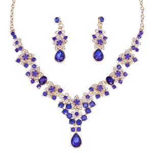 Close-up of golden bridal jewelry set with deep blue teardrop crystals and rhinestones