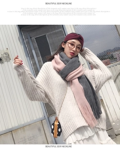 Detail shot of a pink and grey color-block knitted scarf with fringe in outdoor setting
