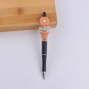 Close-up of black ballpoint pen with a 3D pink silicone flower pot decorative topper
