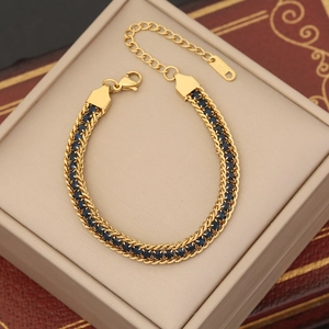 Detail of gold double-woven bracelet with deep blue sapphire-colored zircons and lobster clasp