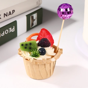 Detailed view of a mini disco ball cake topper with realistic fruit accents and paper base