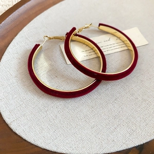 Vue détaillée des boucles d'oreilles créoles en velours bordeaux et métal doré