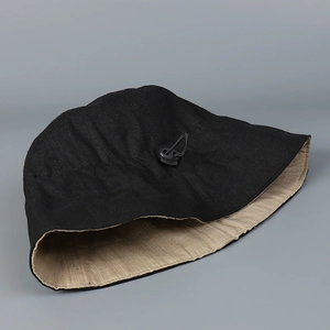 Detail of linen sun hat showing dual-color interior and adjustable drawstring toggle