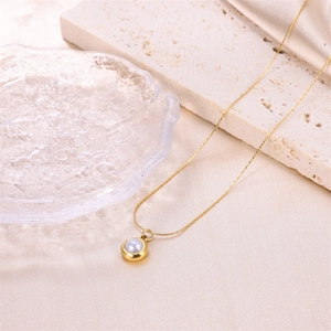Élégant collier en or avec pendentif perle blanche sur tissu en soie et travertin