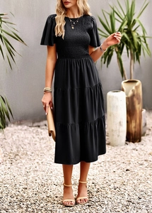 Detail of tiered skirt and shirred bodice on a black midi dress for women