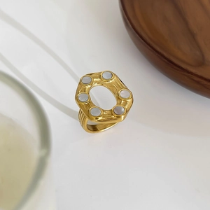 Irregular cutout 18K gold titanium steel ring with white shell inlays on white background